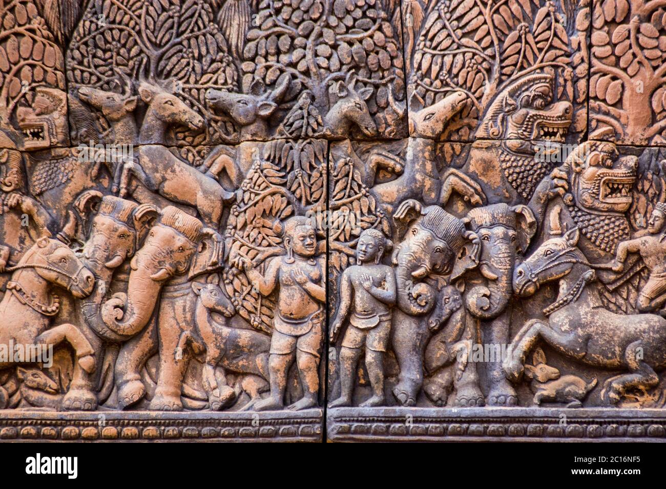 Antica scultura Khmer di Krishna e suo fratello Balarama con gli animali della foresta. Biblioteca del nord al tempio di Banteay Srei, Angkor, Cambogia. Foto Stock