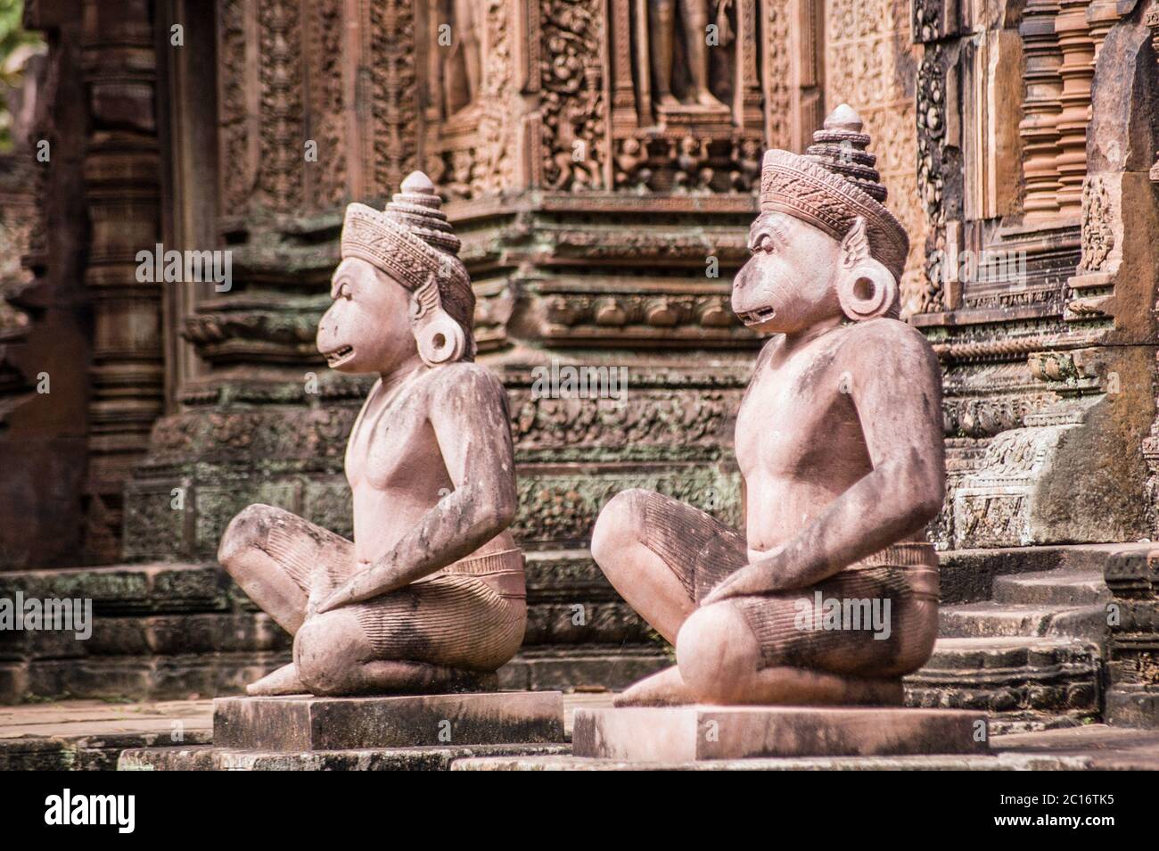Un paio di guardiani della testa della scimmia davanti ad un prasat, o cappella, al tempio di Banteay Srei, Angkor, Cambogia. Oltre 1000 anni. Foto Stock
