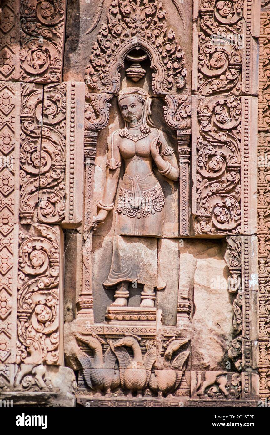 Antica scultura in bassorilievo Khmer di una dea devata con un gangle di oche su un Prasat al tempio di Banteay Srei, Angkor, Cambogia. Scultura in arenaria ov Foto Stock