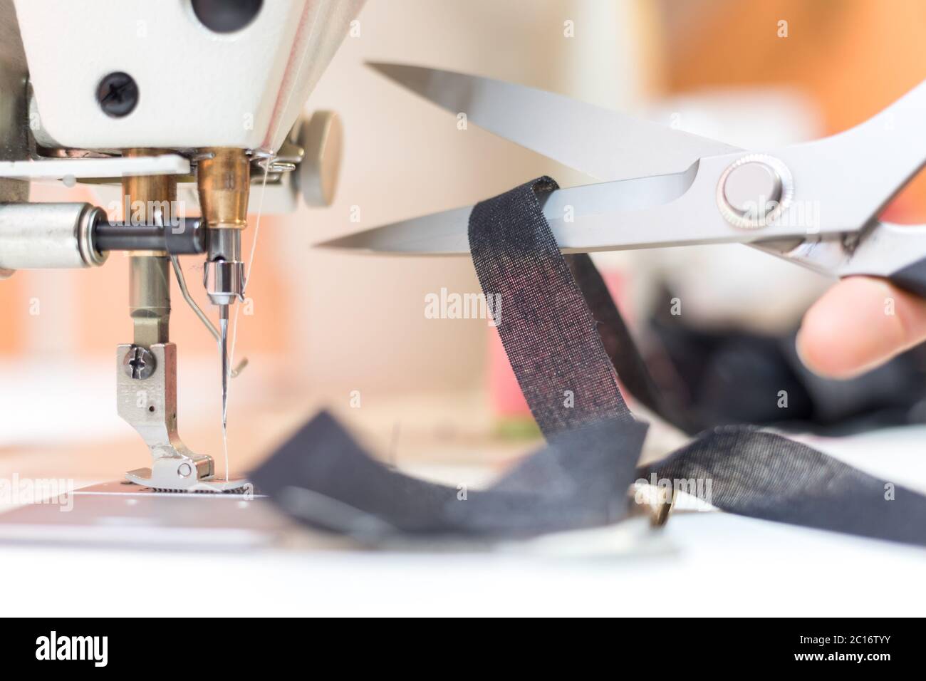 Primo piano di forbici da cucire in metallo con filo da cucire, laboratorio su misura Foto Stock