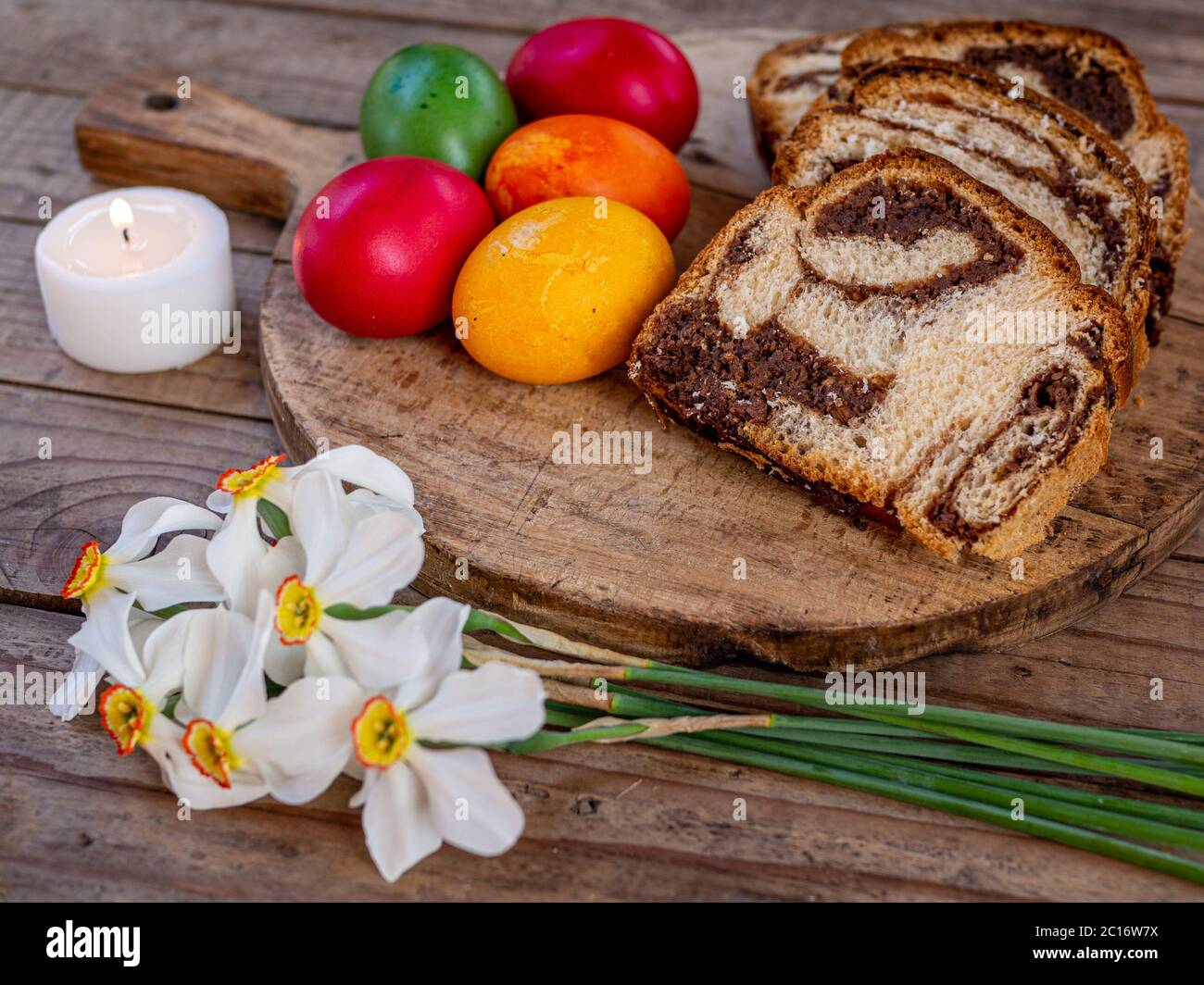 tradizionale rumeno piatto pasquale cozonac o animelle su tavola di legno e colorato uova di pasqua e fiori Foto Stock