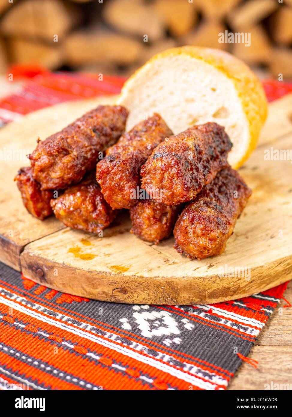 salsiccia di rotolo di carne senza pelle o specialità tradizionali dei balcani romeni otomana mici servita su un piatto di legno in un arredamento rustico Foto Stock