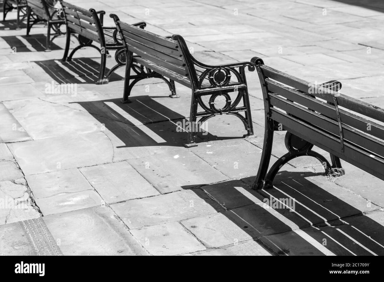 Panchine vuote in una piazza della città Foto Stock