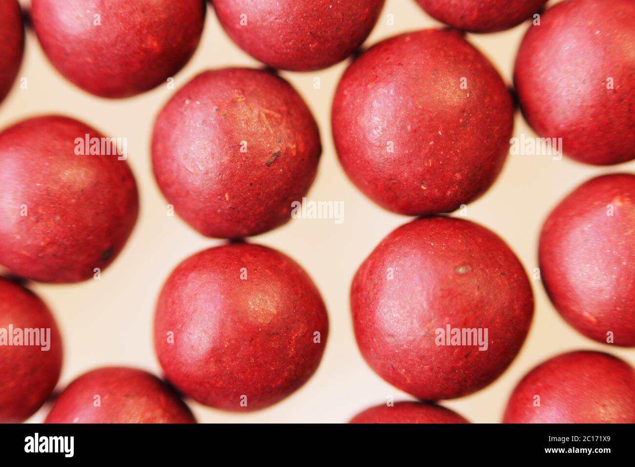Macro foto di molte pillole a forma di sfera rossa. Medicina popolare tibetana dal complesso di erbe. Foto Stock