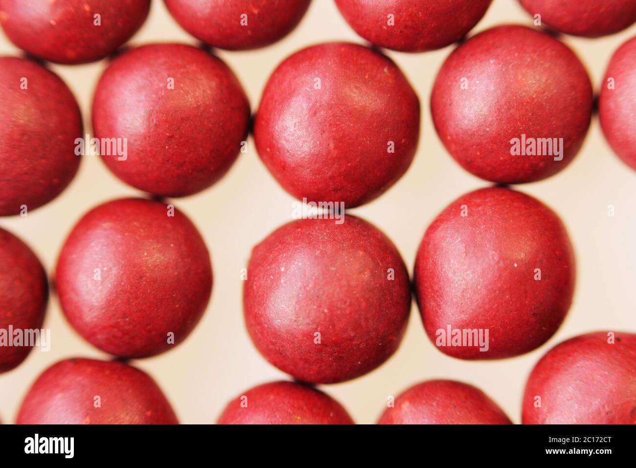 Macro foto di molte pillole a forma di sfera rossa. Medicina popolare tibetana dal complesso di erbe. Foto Stock