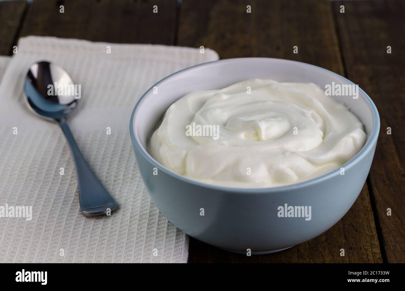 Yogurt greco cremoso naturale su tavolo di legno Foto Stock