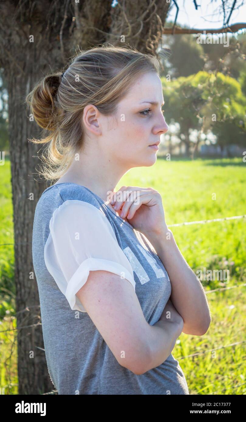 Ritratto di una giovane donna bionda seria che guarda avanti e lontano dalla macchina fotografica Foto Stock