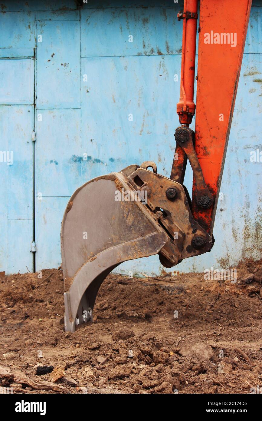 Benna di un vecchio escavatore che lavora in un parcheggio in una giornata di lavoro. Foto Stock