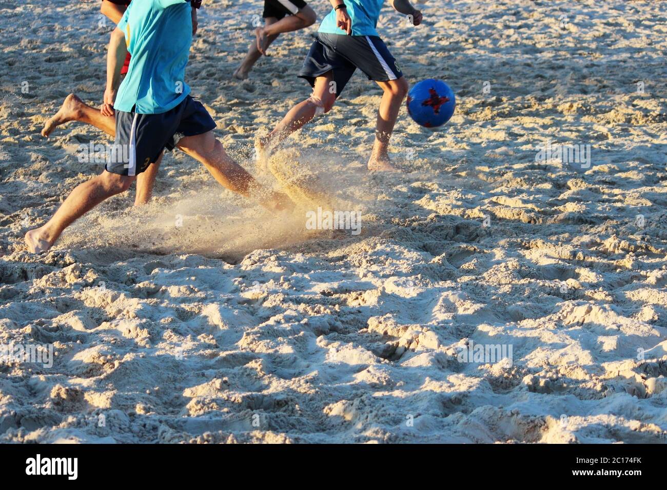 I giovani giocano a calcio in estate sulla piattaforma di sabbia. Foto Stock