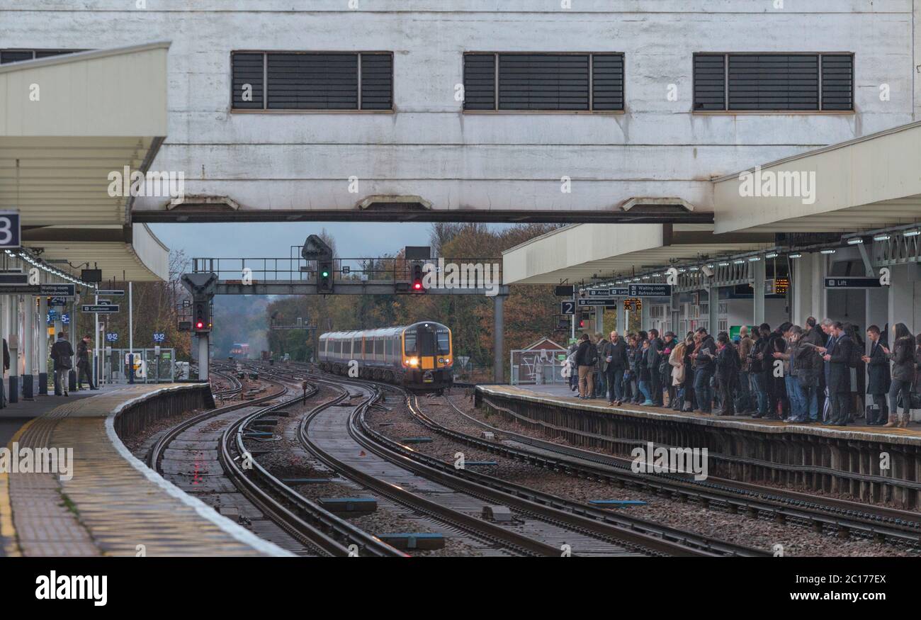 Treni Sud Ovest classe 444 treno elettrico che arriva alle affollate piattaforme della stazione ferroviaria di Surbiton nell'ora di punta del mattino Foto Stock