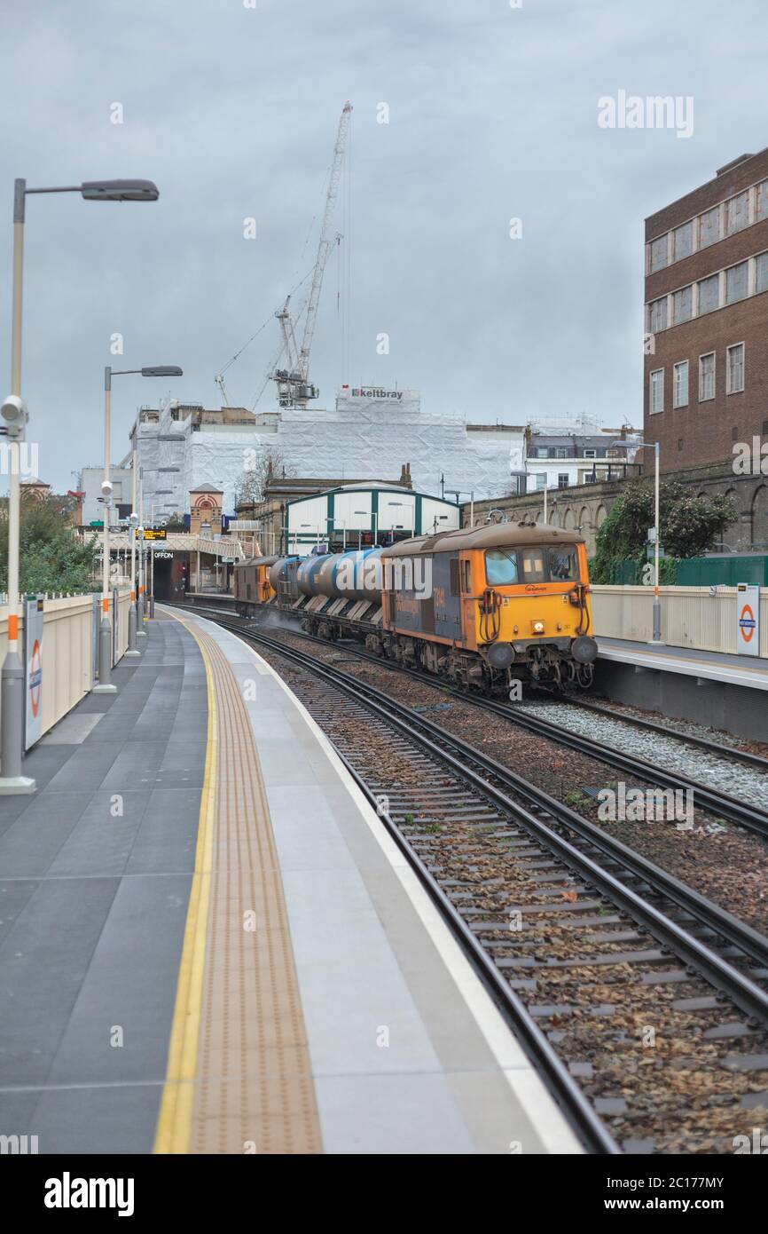 GB Railroad classe 73 locomotiva a doppia modalità sulla linea ovest di Londra con un treno di trattamento ferroviario della rete ferroviaria che eietterà le foglie autunnali dalla linea Foto Stock