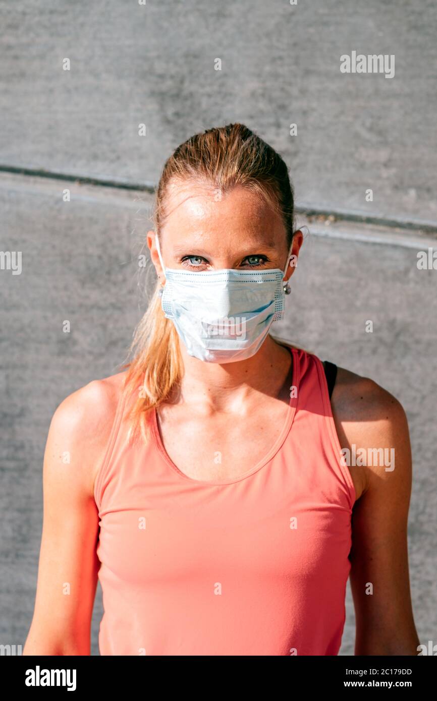 ritratto verticale esterno di una donna sana e sportiva con maschera protettiva Foto Stock