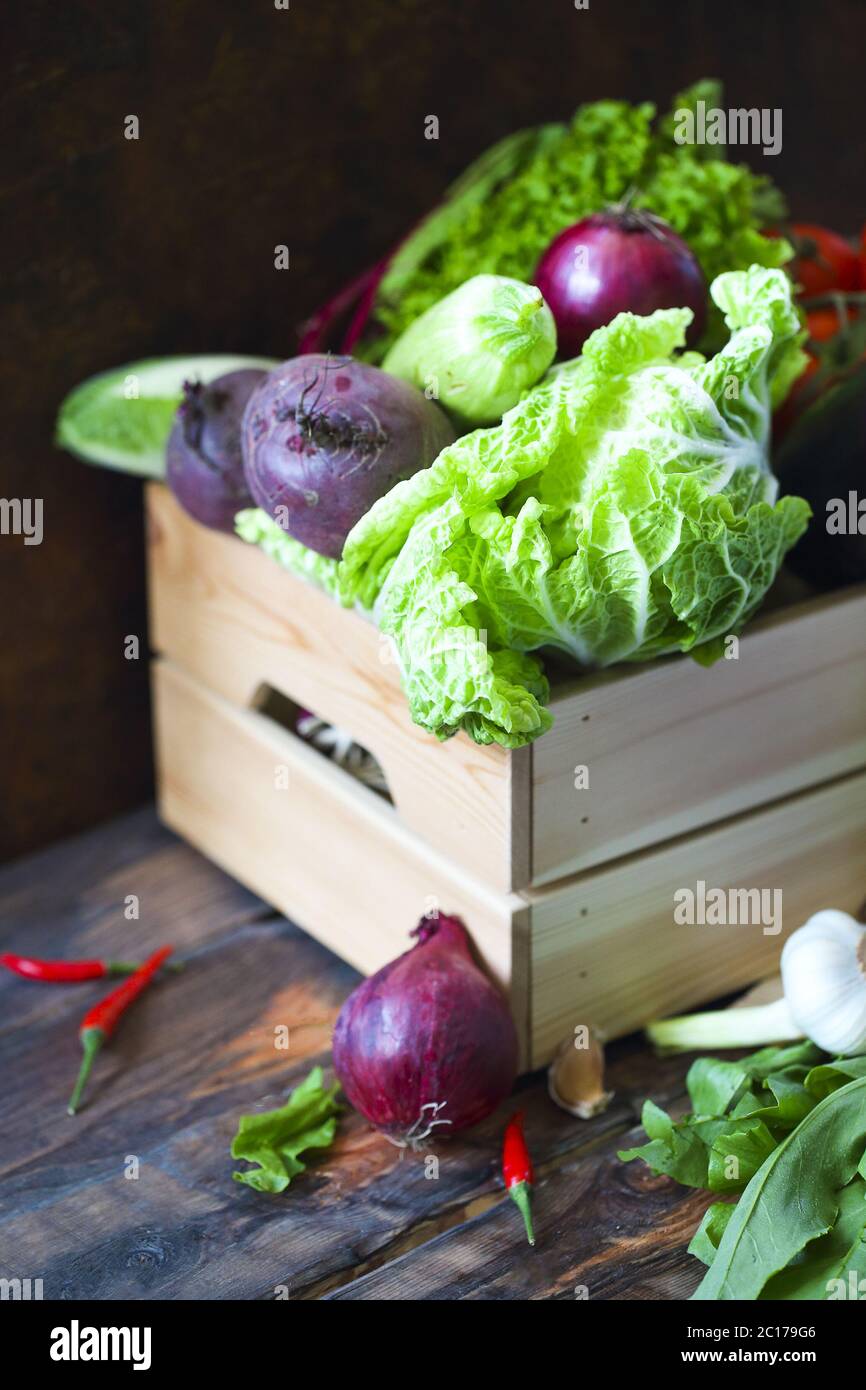 Verdure crude organiche in scatola di legno. Concetto di alimentazione e nutrizione sana Foto Stock