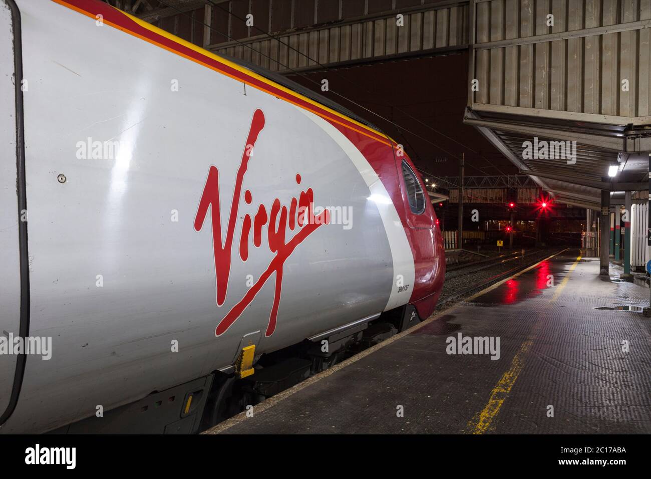 Treni Virgin classe 390 Alstom Pendolino treno 390137 alla stazione ferroviaria di Preston con segnali rossi Foto Stock