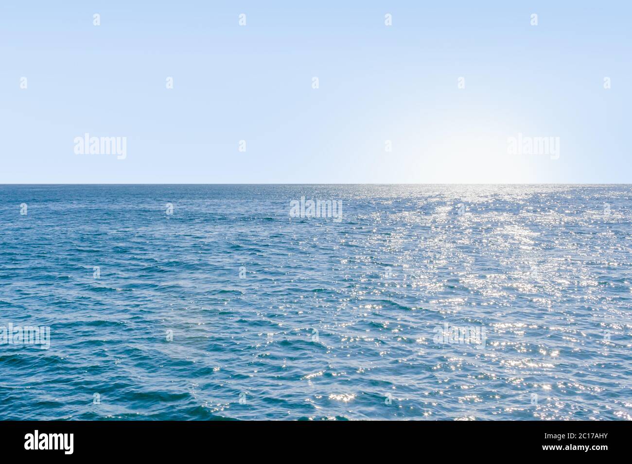 Blu mare calmo con luce solare riflessa su di esso Foto Stock