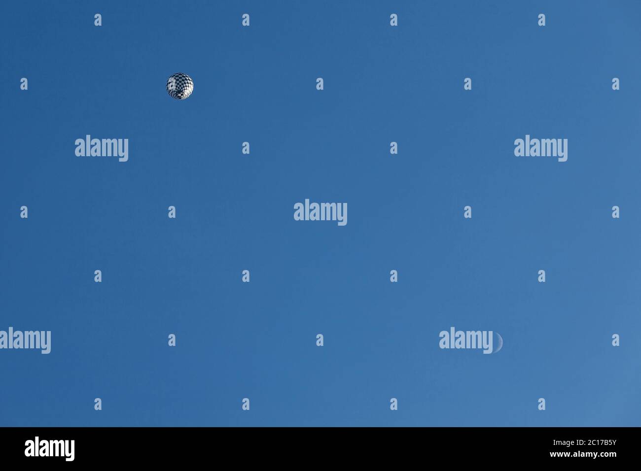 Bianco e nero palloncino in volo e luna visto da sotto Foto Stock