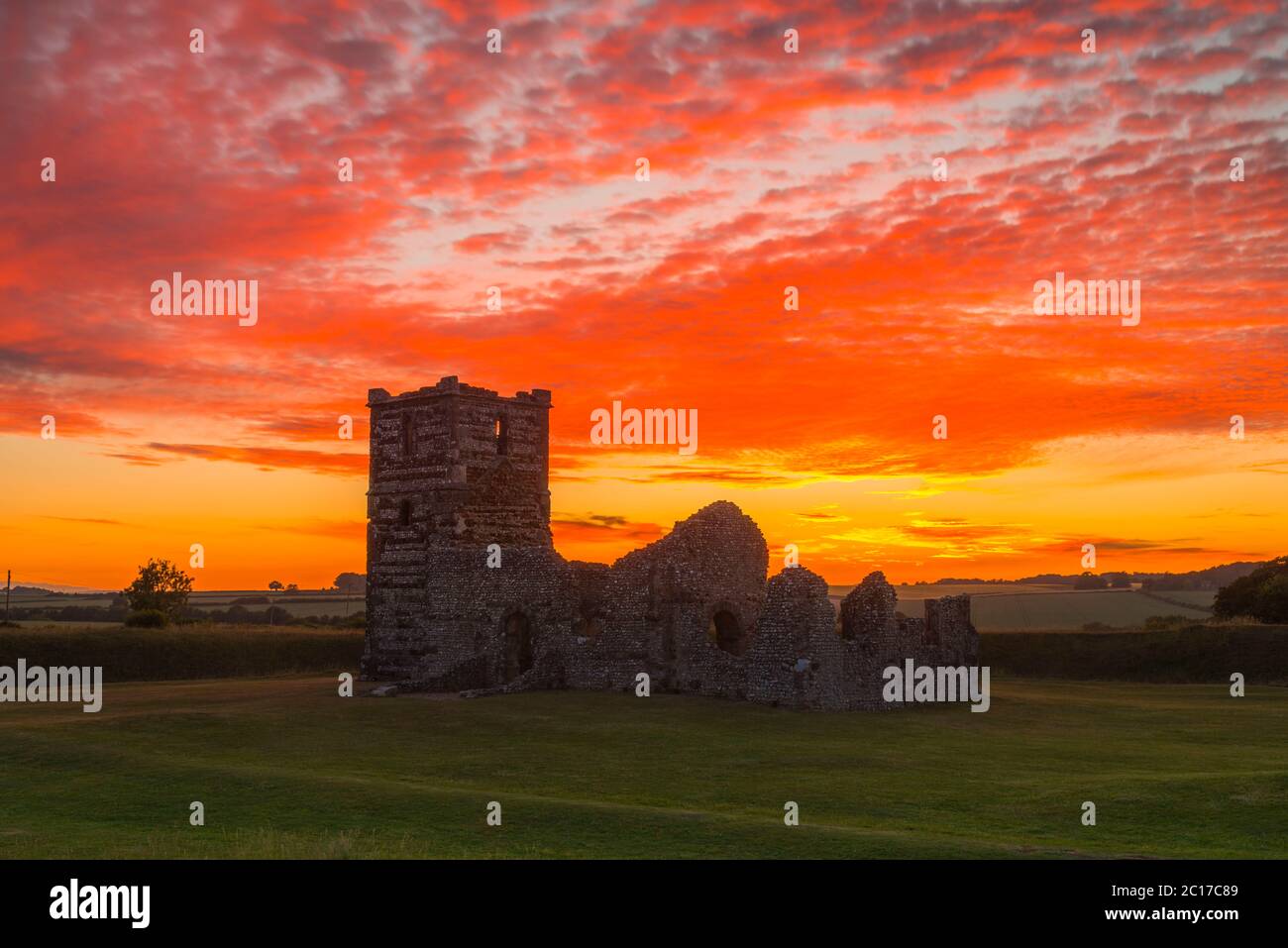 Knowlton, Dorset, Regno Unito. 14 giugno 2020. Regno Unito Meteo. Un tramonto spettacolare con le nuvole che illuminano rosso luminoso sopra la chiesa in rovina a Knowlton in Dorset. Immagine: Graham Hunt/Alamy Live News Foto Stock