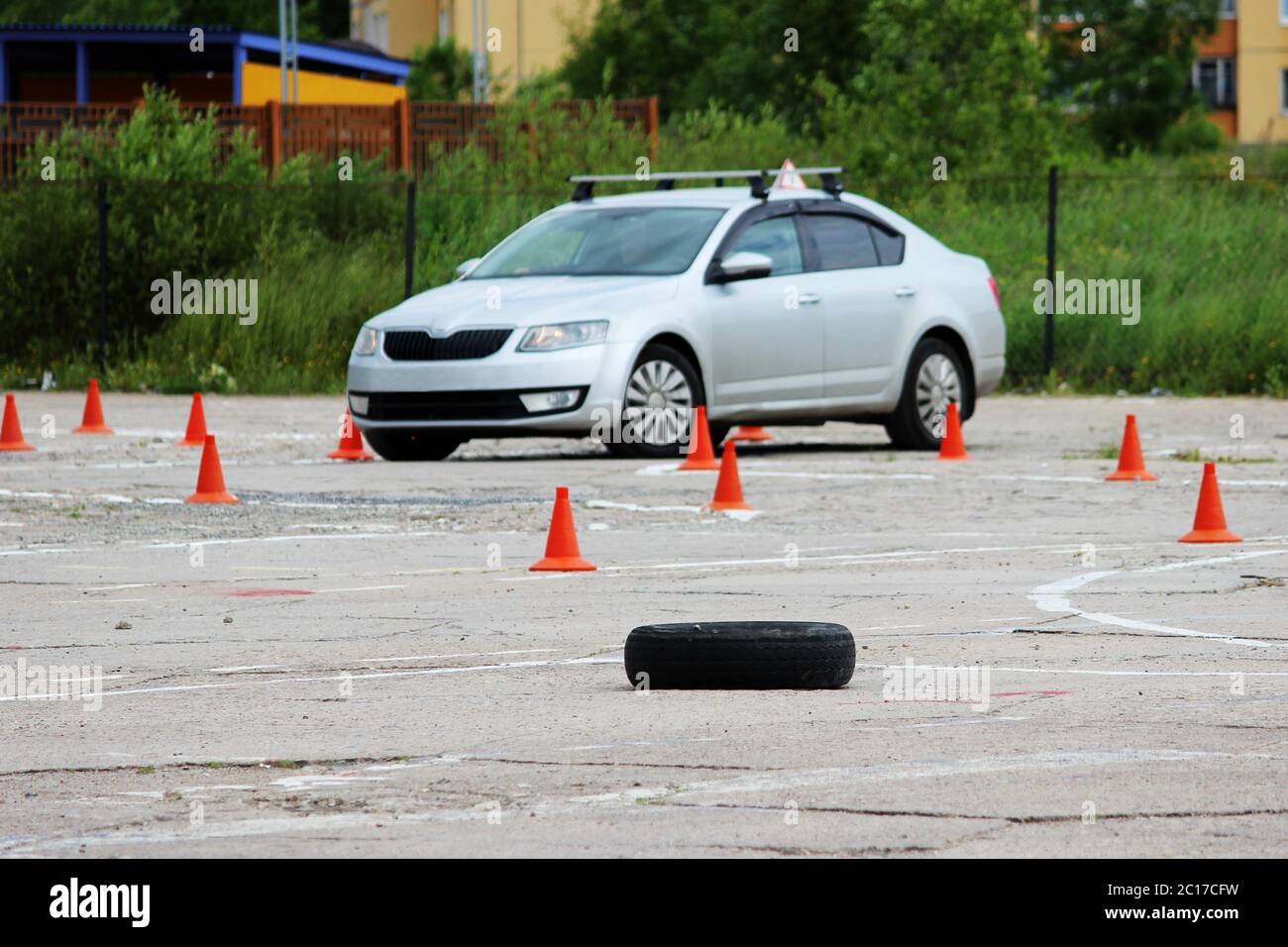 Molti di plastica il traffico di segnalazione di coni e pneumatici in gomma dalle ruote sono sul sito per la formazione di driver dove imparare a cavalcare sulle vetture. Foto Stock