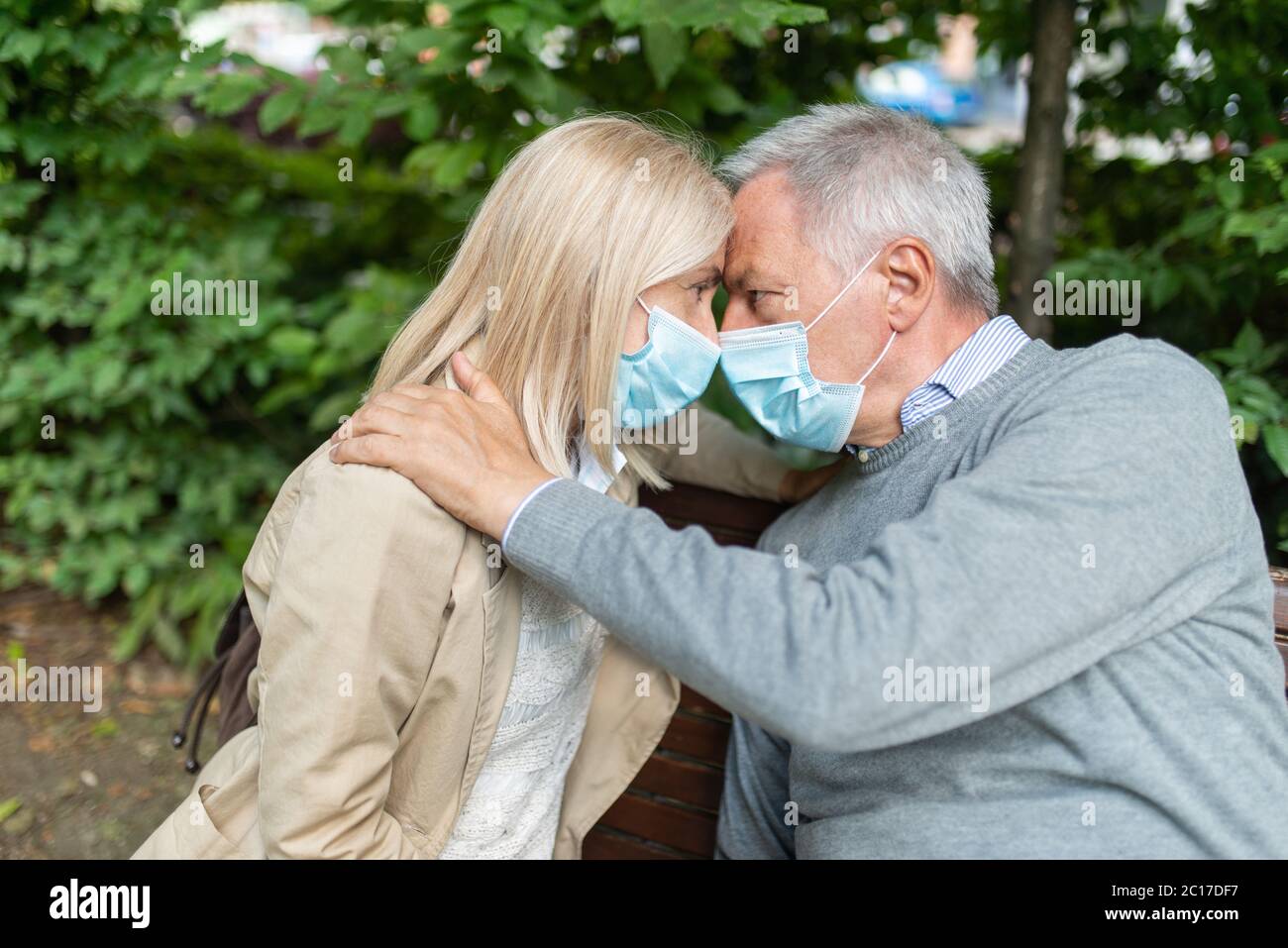 Romantica coppia matura in un parco durante il concetto di pandemia di Coronavirus, amore e speranza Foto Stock