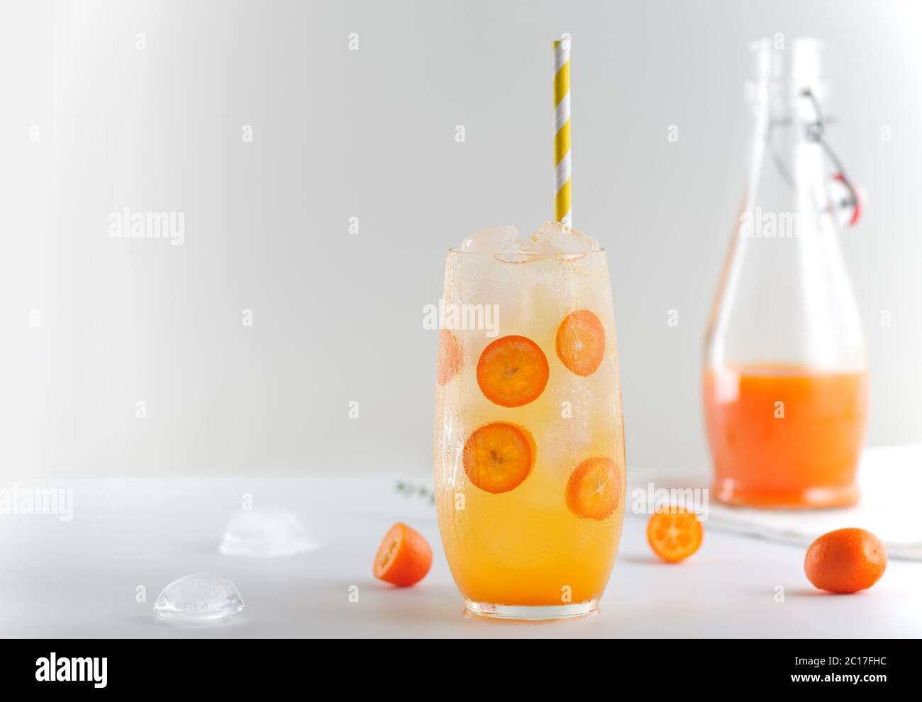 Estate disintossicazione con kumquat, tangerini e cubetti di ghiaccio su sfondo bianco. Immagine in orientamento orizzontale con spazio per il testo, primo piano. Foto Stock