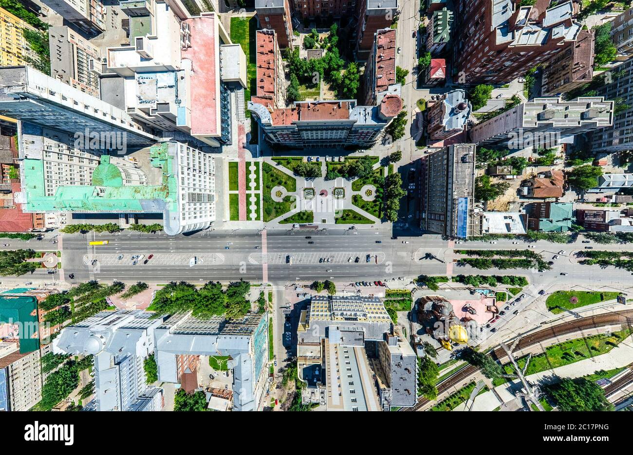 Antenna vista città con incroci e strade, case, edifici, parchi e parcheggi. Estiva soleggiata immagine panoramica Foto Stock