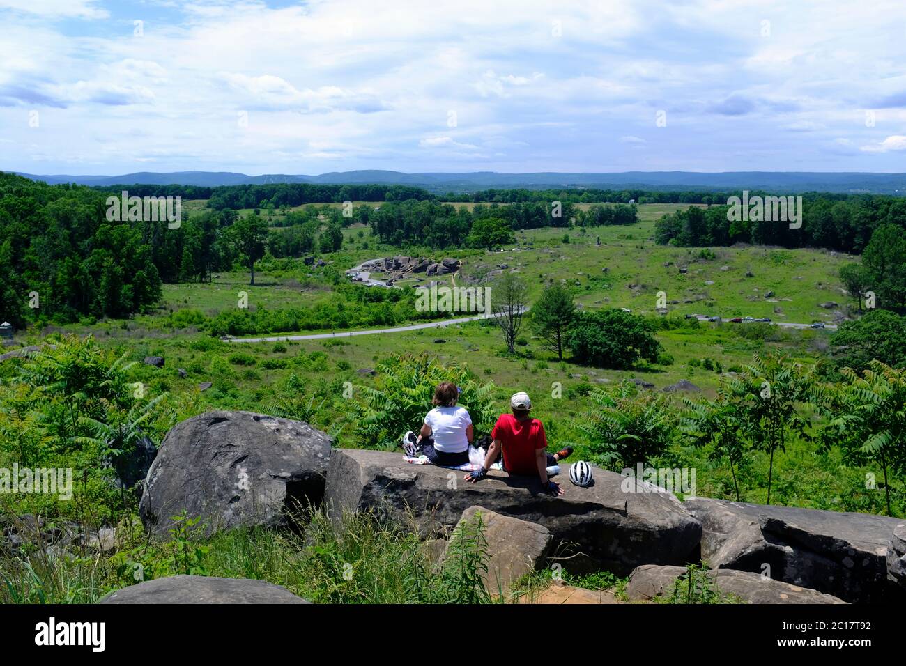 Due turisti seduti su Little Round Top e guardando verso Devil's Den nel Gettysburg National Military Park Foto Stock