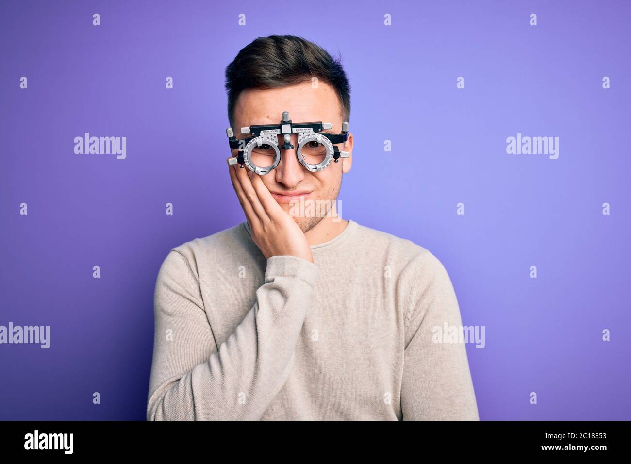Giovane bell'uomo caucasico che indossa occhiali da vista su sfondo viola  pensando stanco e annoiato con problemi di depressione con crosse Foto  stock - Alamy