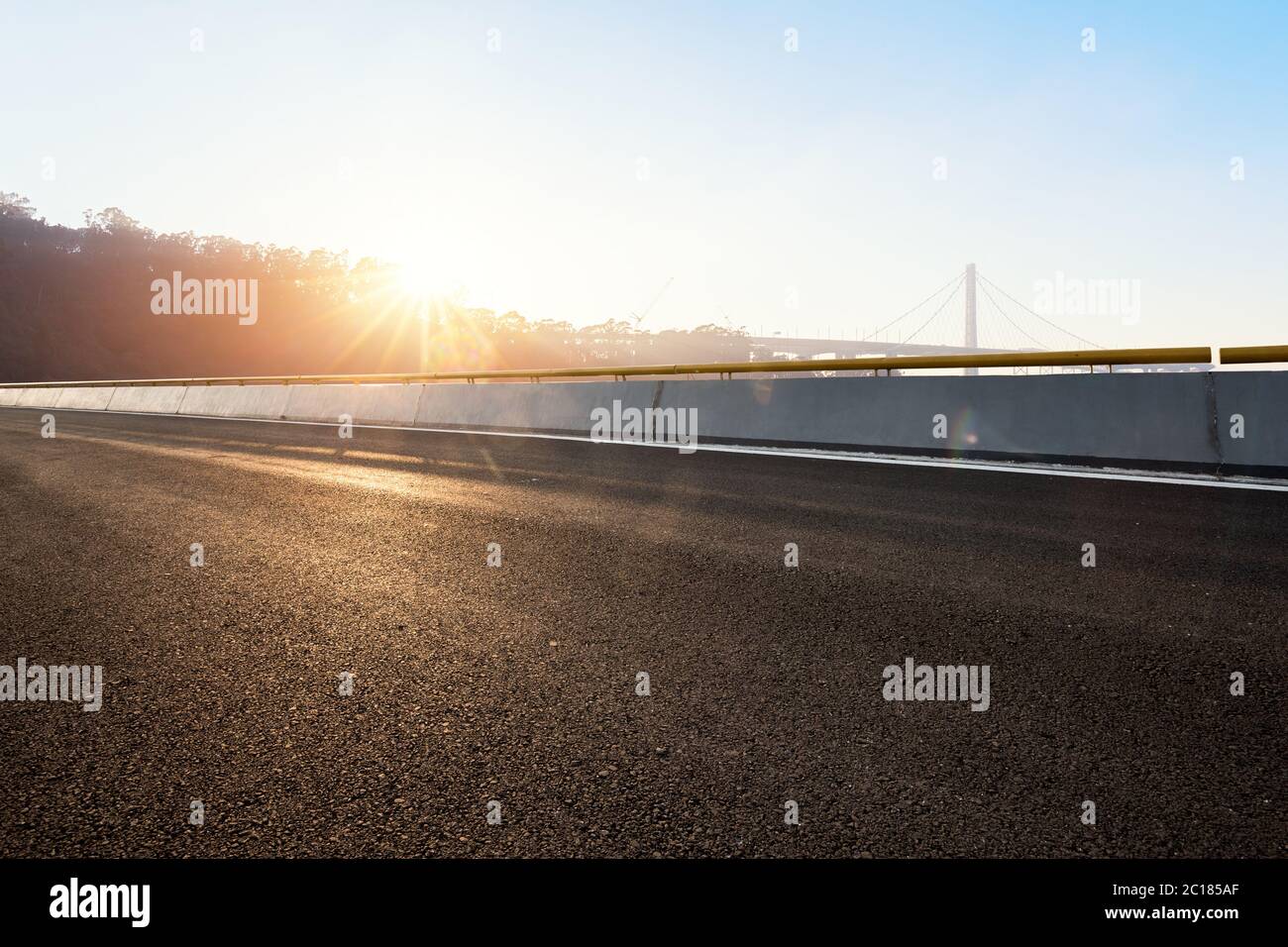 strada vuota con ponte sospeso con fascio solare Foto Stock