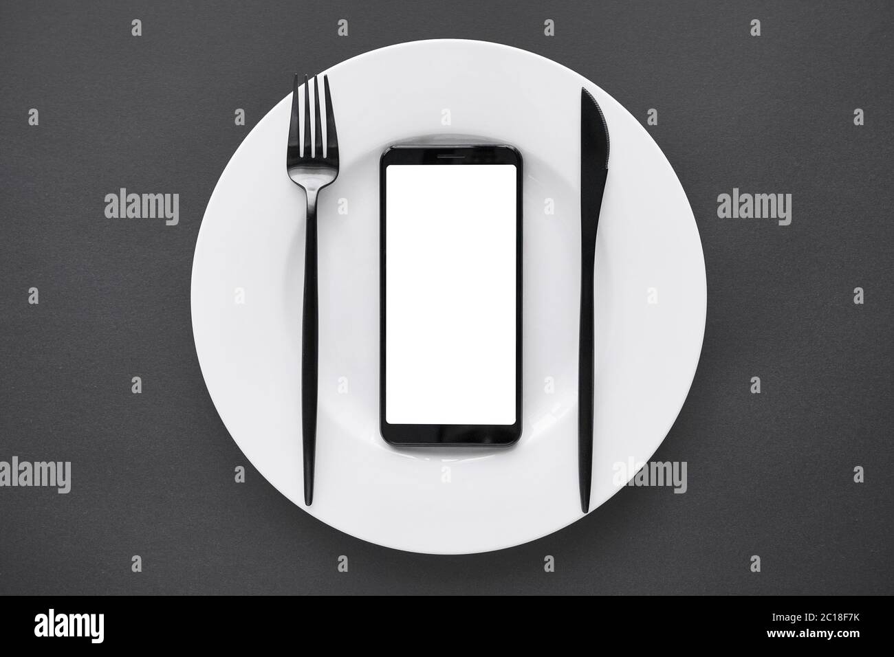 Lo schermo mock-up dello smartphone su sfondo nero con piastra bianca come applicazione per la consegna di alimenti. Foto Stock
