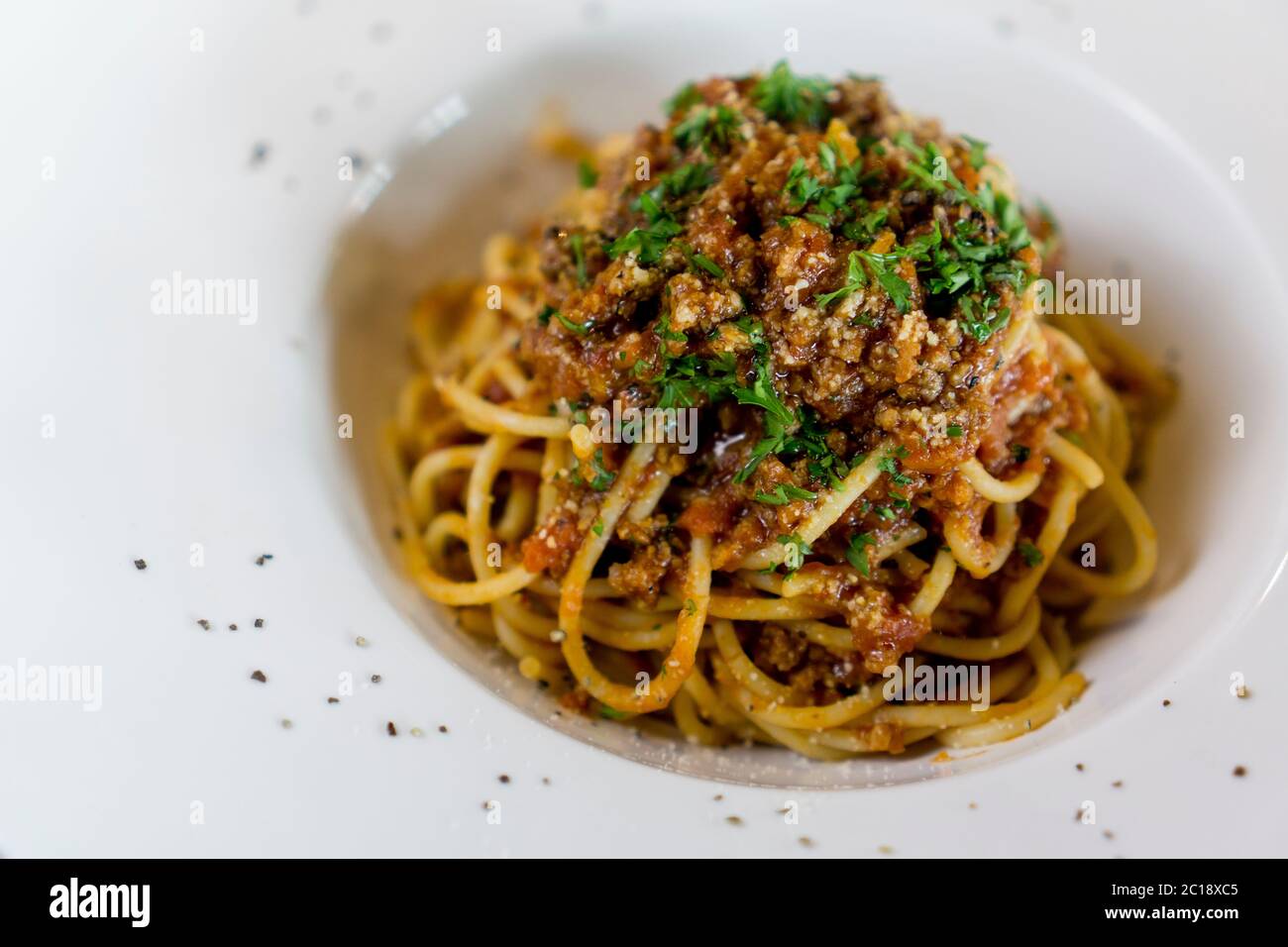 Piatto di deliziosi spaghetti alla Bolognaise o bolognese con salato manzo tritato e salsa di pomodoro guarnita con parmigiano. Foto Stock