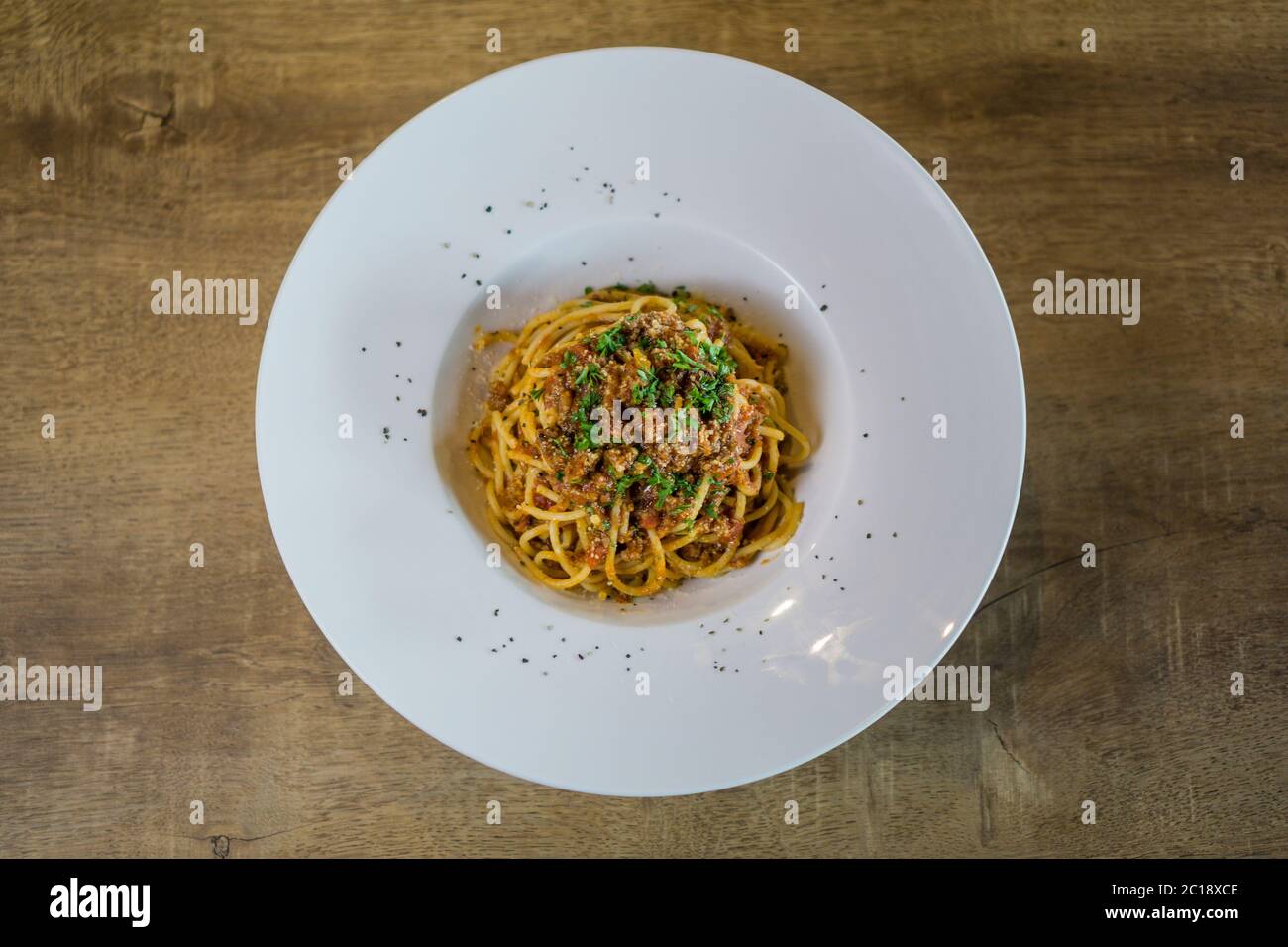 Piatto di deliziosi spaghetti alla Bolognaise o bolognese con salato manzo tritato e salsa di pomodoro guarnita con parmigiano. Foto Stock