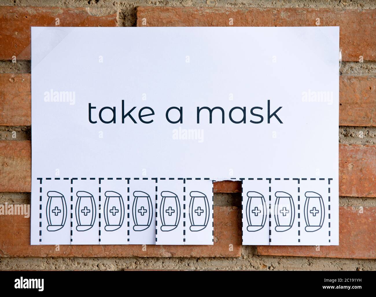 Strappare la carta sulla parete di mattone con la frase 'prenda una maschera'. Essere responsabili su ciò che si fa. Foto Stock