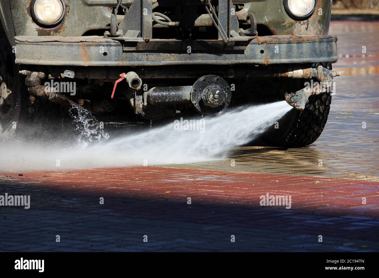 Attrezzatura speciale montata sul carrello per la pulizia stradale con getti d'acqua. Pulizia della zona dalle lastre di pavimentazione. Foto Stock