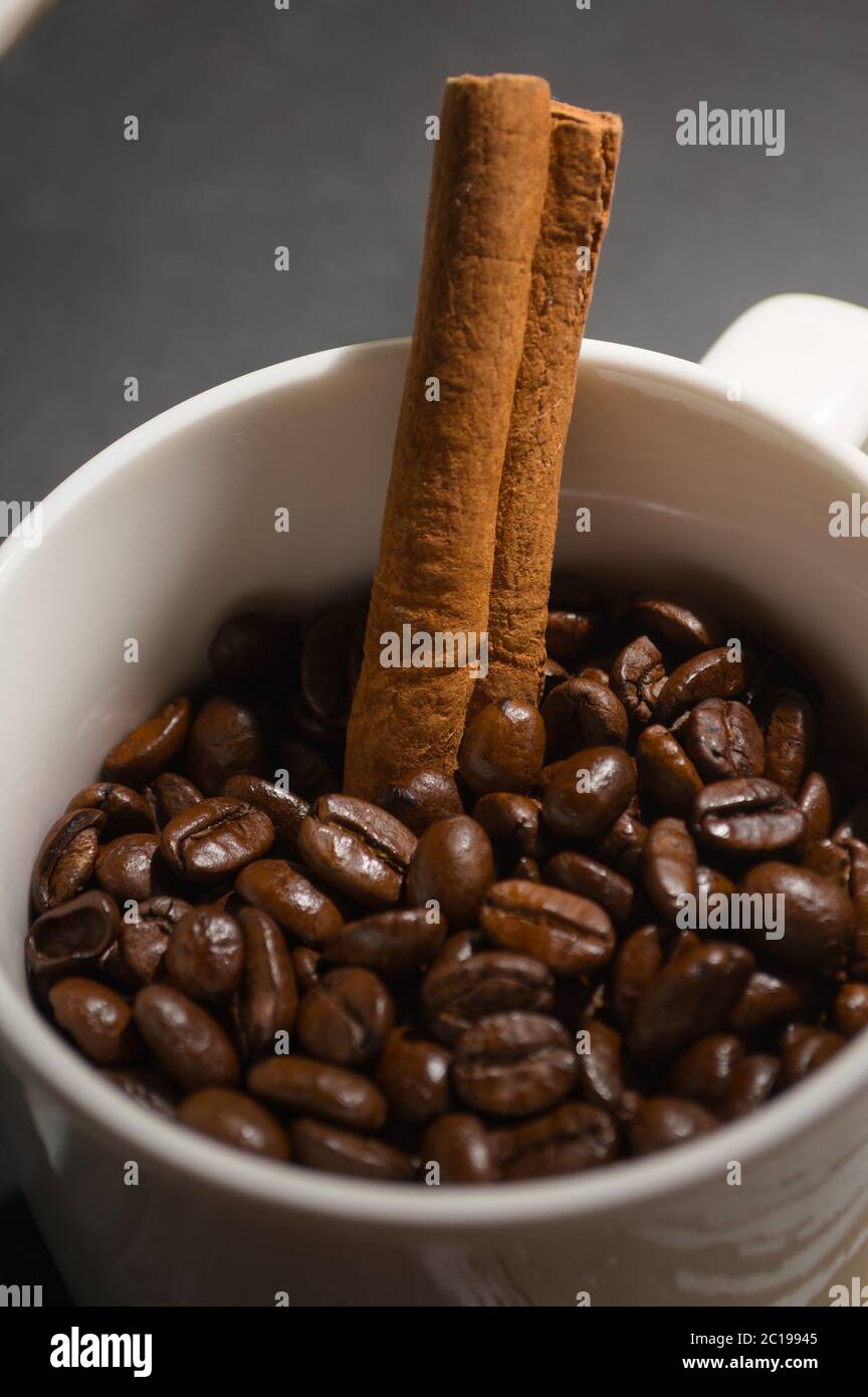 Chicchi di caffè e cannella in una tazza Foto Stock