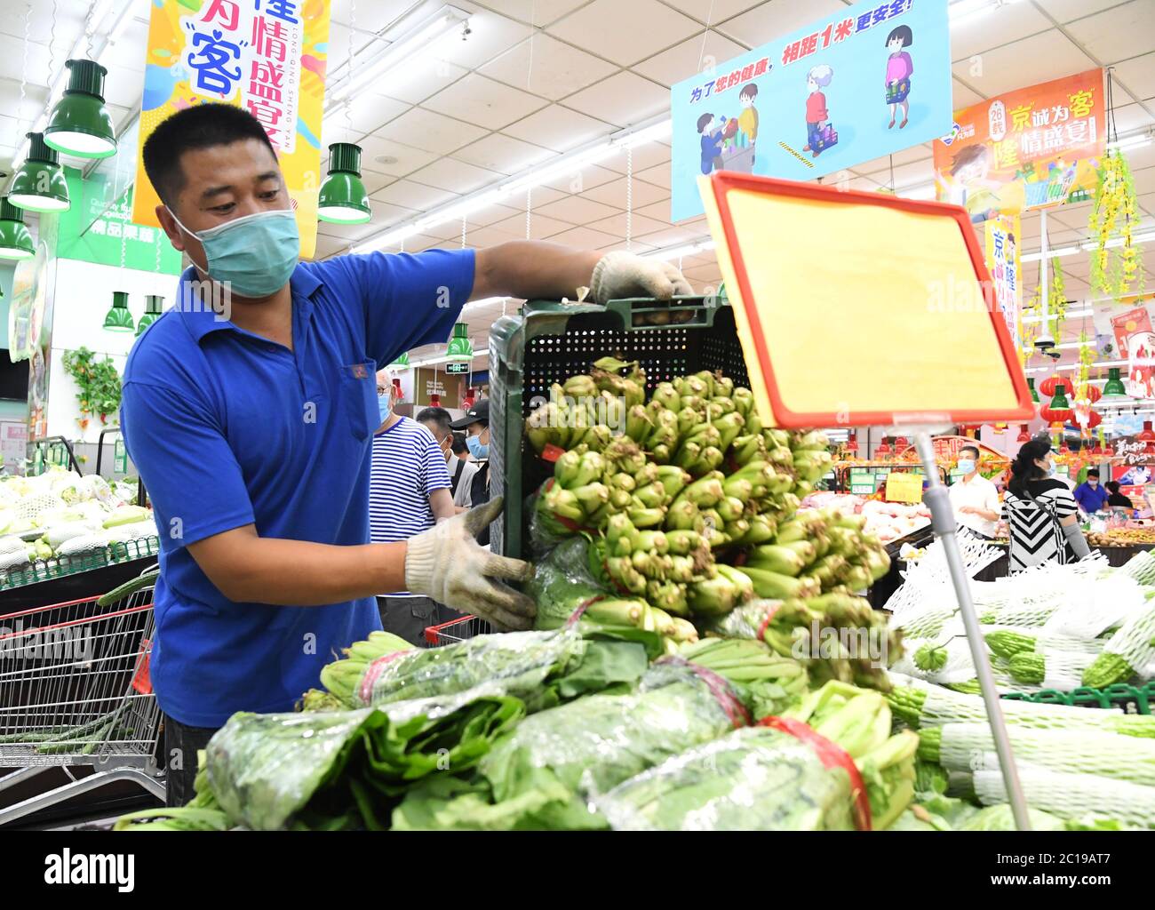 Pechino, Cina. 15 giugno 2020. Un membro dello staff organizza verdure presso una filiale del supermercato Jingkelong a Pechino, capitale della Cina, il 15 giugno 2020. Jingkelong, una catena di supermercati, è riuscita a garantire un approvvigionamento diretto e adeguato di ortaggi e frutta dalle basi di produzione intorno a Pechino, dopo la sospensione del mercato all'ingrosso Xinfadi. Credit: Ren Chao/Xinhua/Alamy Live News Foto Stock