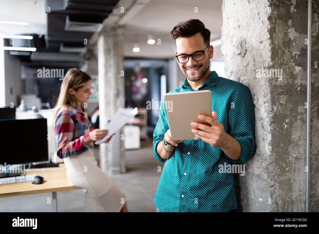 Giovane uomo utilizzando la tecnologia digitale compressa in corporate business office Foto Stock