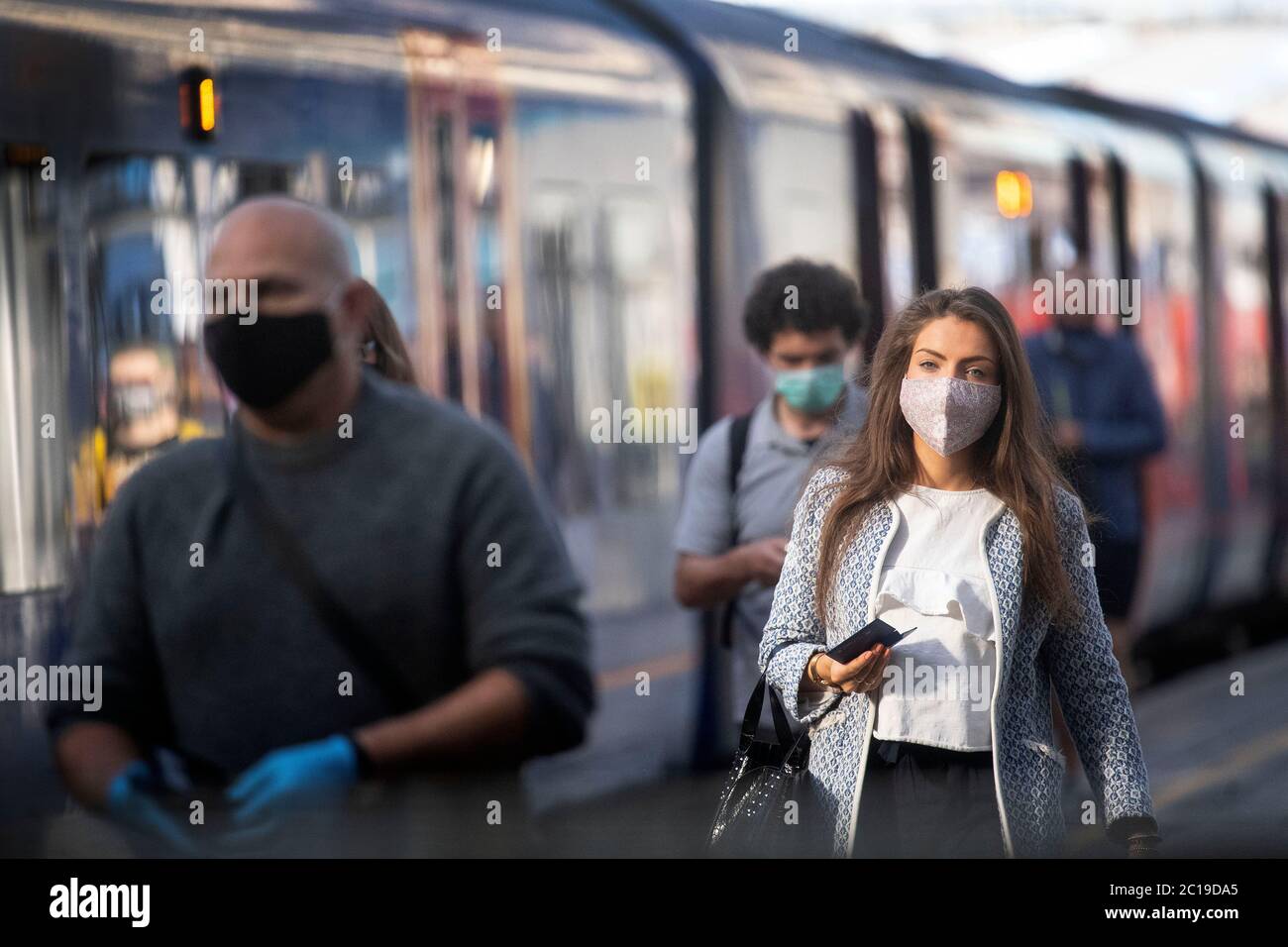 I passeggeri che indossano maschere alla stazione di Waterloo a Londra, come rivestimenti per il viso diventano obbligatori sui trasporti pubblici in Inghilterra con l'allentamento di ulteriori restrizioni di blocco durante la pandemia di coronavirus. Foto Stock