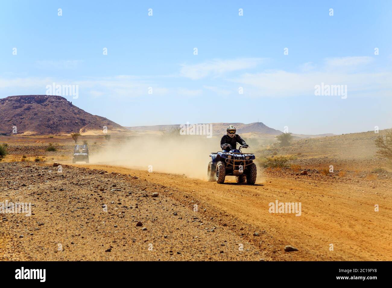 Giovane uomo che guida in quad nel deserto Foto Stock