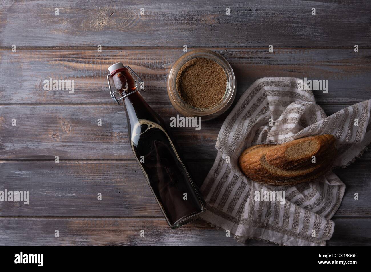 Vista dall'alto, kvass russo tradizionale fatto in casa in bottiglia di vetro con lievito e pane. Ottima bevanda rinfrescante per l'estate Foto Stock