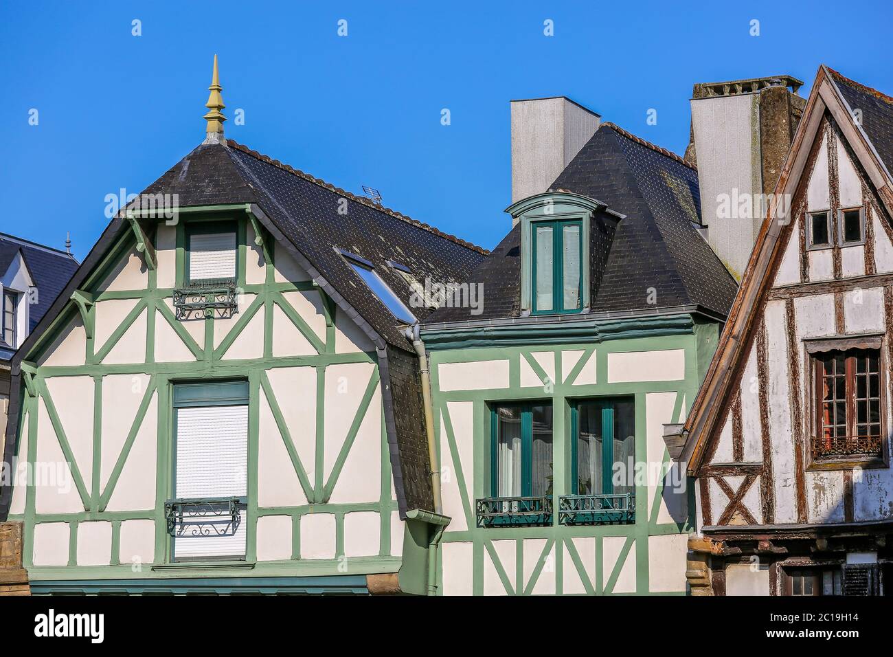 Si tratta di una vista ravvicinata di un cottage in stile Tudor bianco in Bretagna, Francia con travi esterne verdi e marroni. Foto Stock