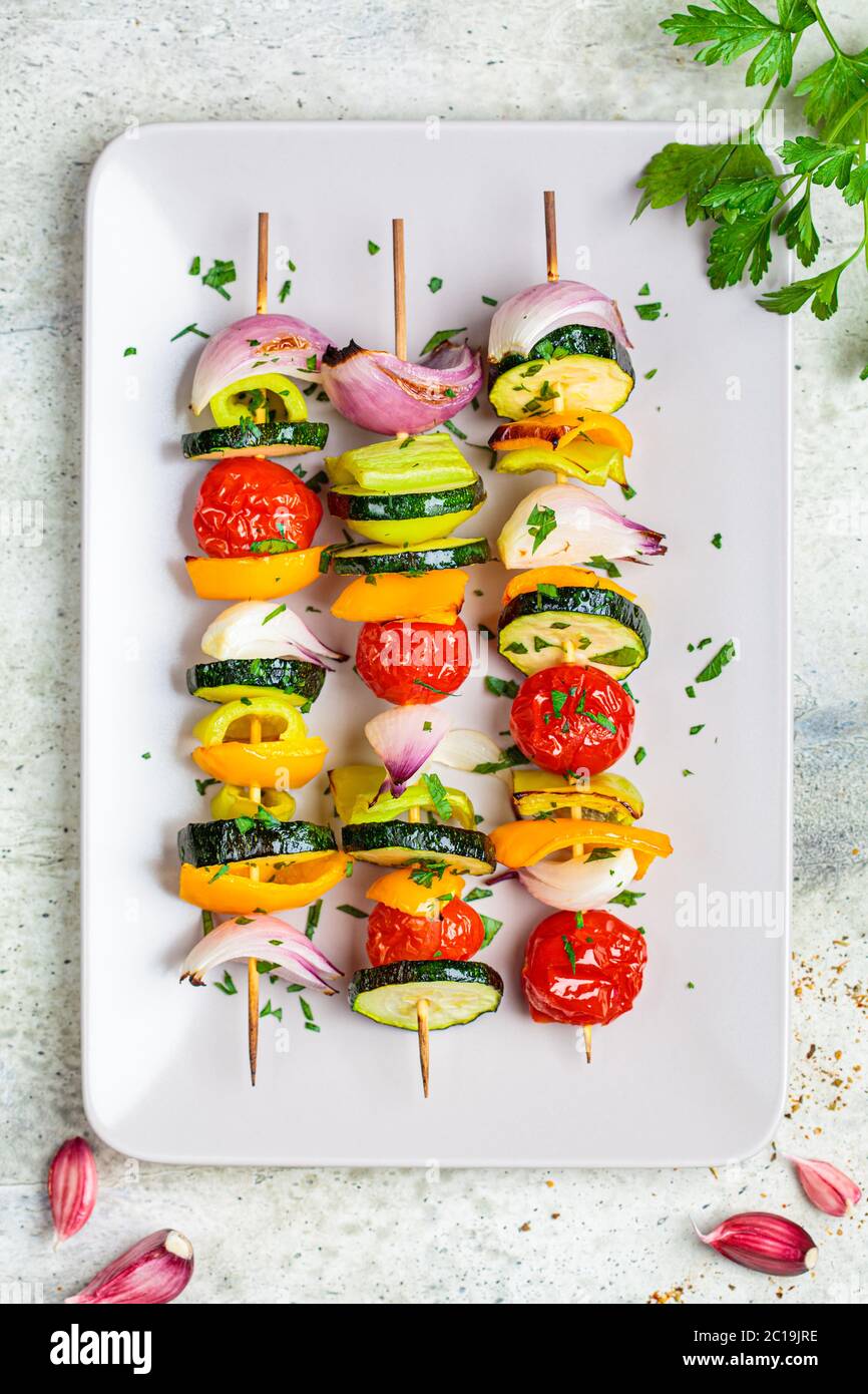 Spiedini grigliati di verdure su una piastra rettangolare grigia. Concetto di cibo vegano. Foto Stock