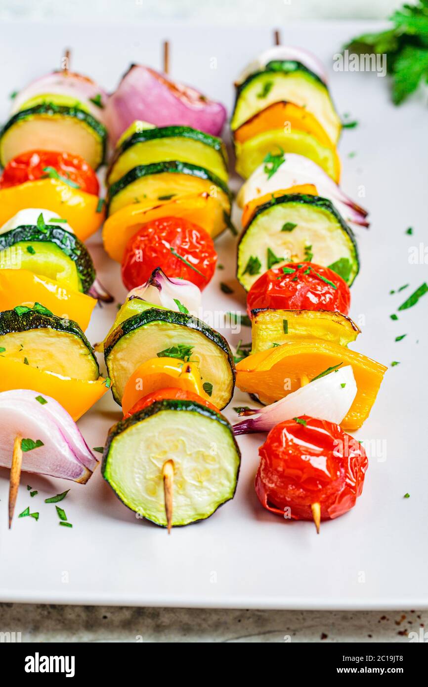 Spiedini grigliati di verdure su una piastra rettangolare grigia. Concetto di cibo vegano. Foto Stock