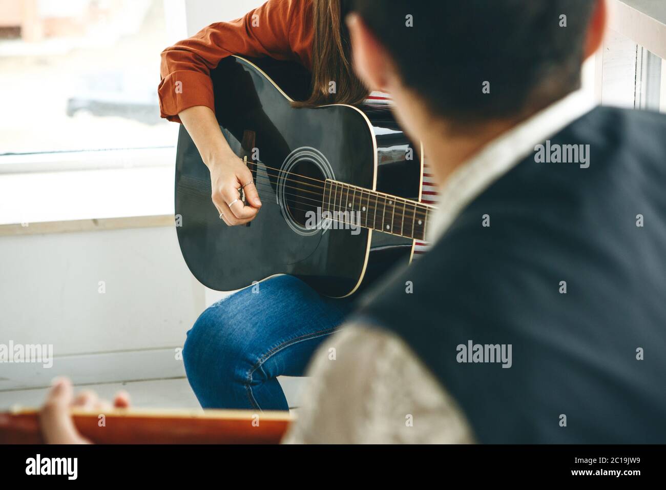 Imparare a suonare la chitarra. L'insegnante spiega allo studente le basi per suonare la chitarra. Lezioni individuali di scuola domestica o extracurricolare. Foto Stock