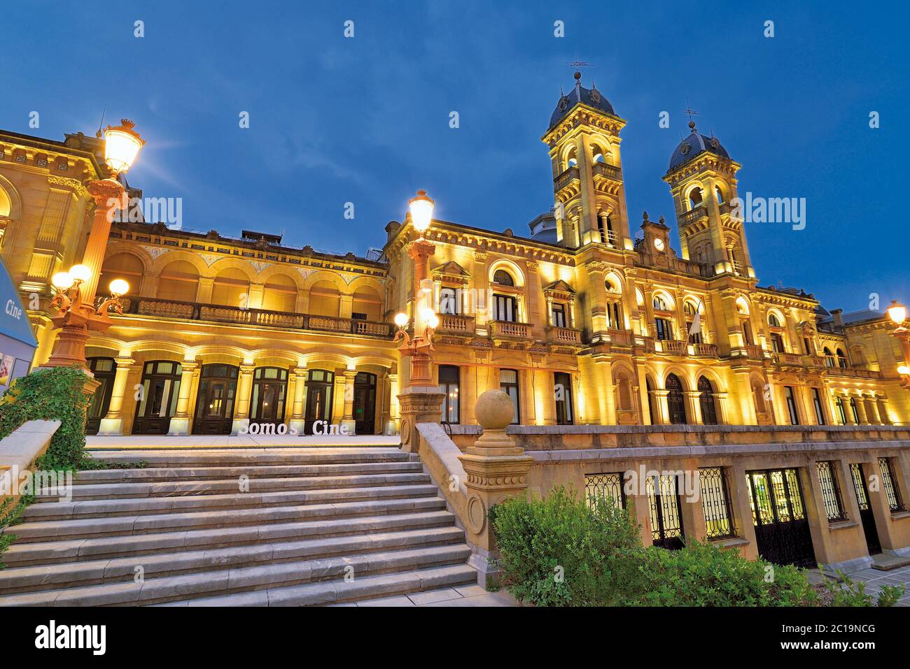 19 ° edificio illuminato notturno con scalinata esterna e due torri (Municipio di San Sebastian) Foto Stock