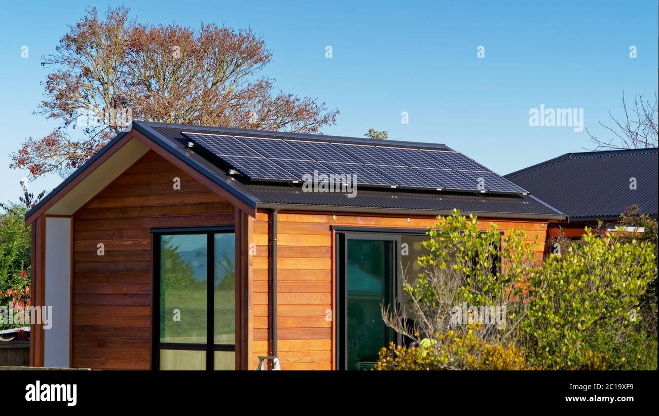 Vivere fuori dalla griglia. I pannelli solari che forniscono energia elettrica ad una griglia fuori casa in Nuova Zelanda il paese indietro. Foto Stock