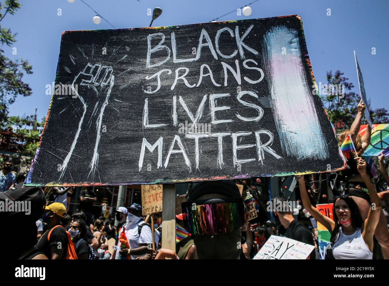Los Angeles, Stati Uniti. 14 Giugno 2020. Un protester tiene un cartello che dice 'Black Trans Lives Matter' durante la marcia. Migliaia di manifestanti si sono incontrati domenica a marzo a Hollywood e a West Hollywood in una marcia di solidarietà anti-razzismo. Il giorno originariamente era destinato a tenere la Parata DI LA Pride, ma la Parata di Pride era stata precedentemente annullata a causa della pandemia COVID-19. Gli organizzatori hanno detto all'inizio di questo mese che avrebbero organizzato una marcia in solidarietà con la questione Black Lives e contro la brutalità e l'oppressione della polizia. Credit: SOPA Images Limited/Alamy Live News Foto Stock