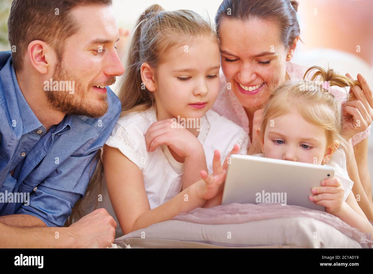 Famiglia e bambini giocano insieme al tablet PC a casa Foto Stock