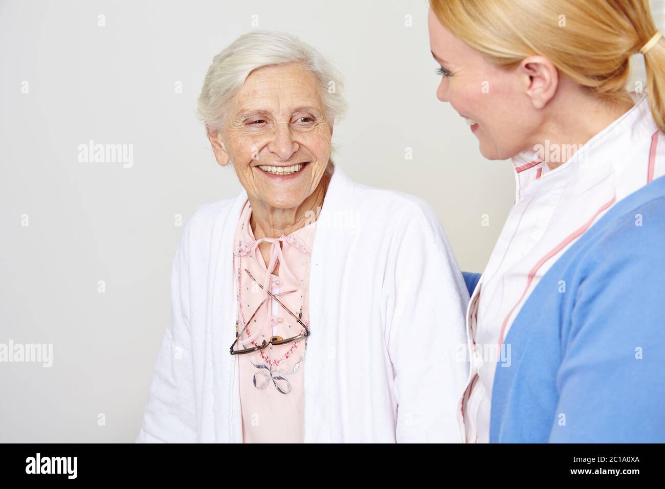 Felice anziana sorride con un infermiere geriatrico nella casa di cura Foto Stock