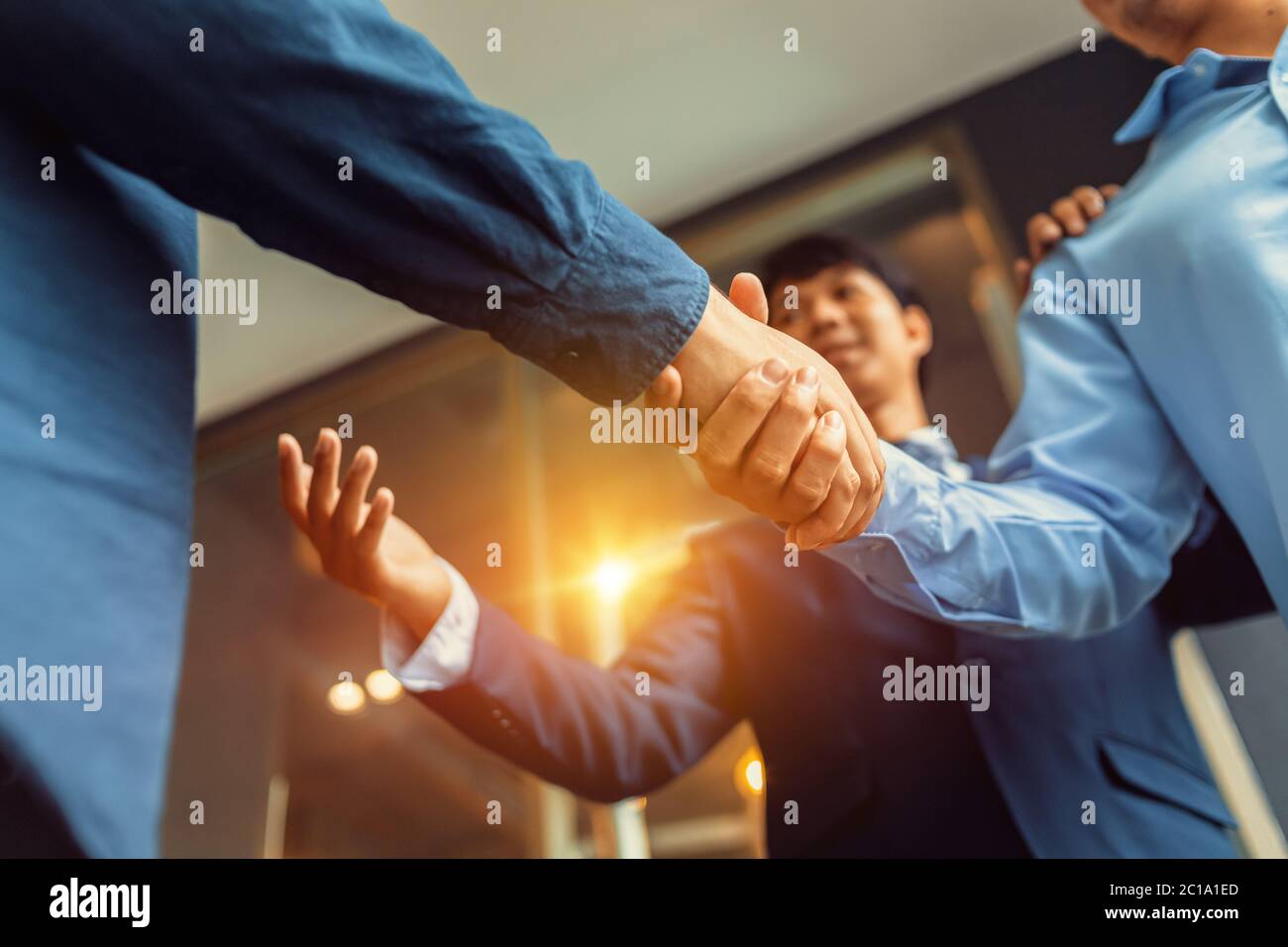 Il lavoro si muove a mani sbattenti, terminando la riunione. Uomini d'affari riusciti che si battono a mano dopo un buon affare. Foto Stock