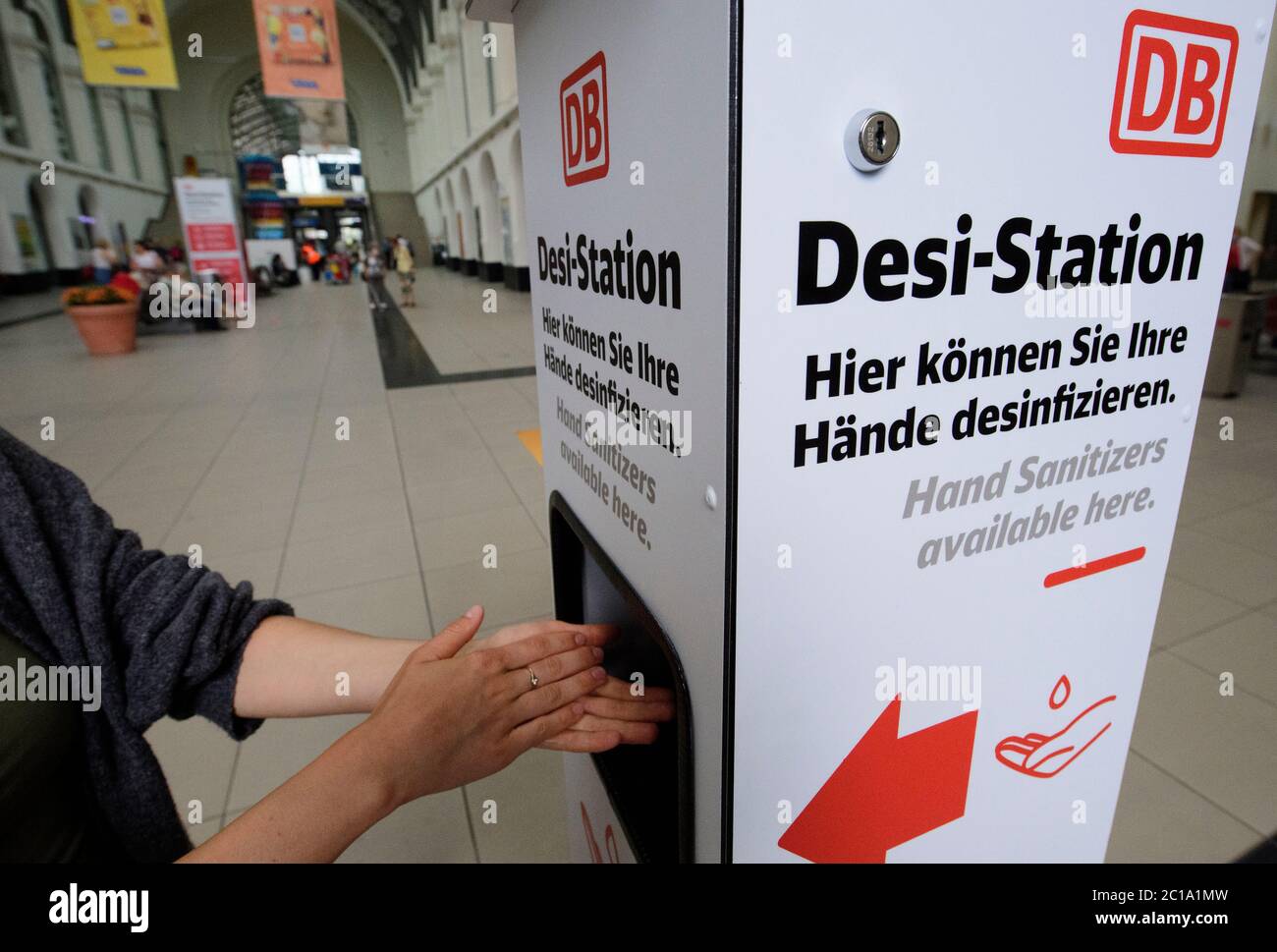 Dresda, Germania. 15 giugno 2020. Una donna le disinfetta le mani presso una stazione Desi della stazione centrale di Dresda. Deutsche Bahn ha presentato oggi misure di pulizia e disinfezione nei treni e nelle stazioni. Si sta utilizzando un nuovo tipo di procedura in cui i corrimano vengono puliti e disinfettati utilizzando la luce UV-C a onde corte. Credit: Robert Michael/dpa/Alamy Live News Foto Stock